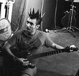 Photo de Vaquette en train d'accorder sa guitare avant un spectacle au squat de la Miroiterie